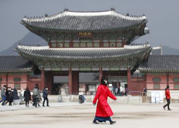 Una mujer con una mascarilla camina por delante del Palacio Gyeongbok, uno de los monumentos más conocidos de Corea del Sur, en Seúl, Corea del Sur, el 22 de febrero de 2020. Foto: Lee Jin-man / AP.