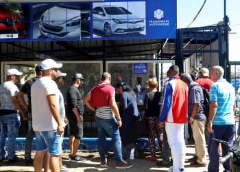 Varias personas hacen fila para la compra de autos de segunda mano en La Habana, cuya venta en moneda libremente convertible por parte del gobierno cubano comenzó el martes 25 de febrero de 2020. Foto: Ernesto Mastrascusa / EFE.