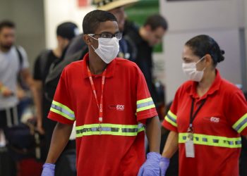 Los empleados del aeropuerto usan máscaras como precaución contra la propagación del nuevo coronavirus COVID-19 mientras trabajan en el Aeropuerto Internacional de Sao Paulo en Brasil, el miércoles 26 de febrero de 2020. Foto: Andre Penner / AP.