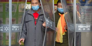 Dos personas con mascarillas salen de una tienda Walmart en Beijing, el sábado 1 de febrero de 2020. Foto: AP/Mark Sjefeelbein