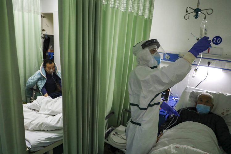 Una enfermera comprueba el estado de un paciente en un ala de aislamiento para pacientes del 2019-nCoV en un hospital de Wuhan, en la provincia china de Hubei. Foto: Chinatopix via AP.