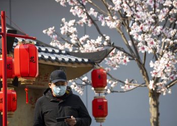 Un hombre que porta una mascarilla para protegerse del nuevo coronavirus observa junto a un decorado que promueve una película en Beijing, China, el miércoles 19 de febrero de 2020. Foto: Ng Han Guan/AP.