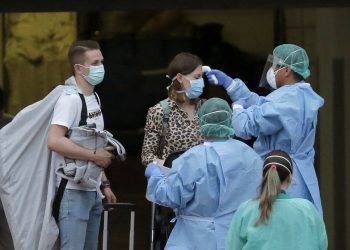 Personal sanitario toma la temperatura a una huésped del hotel H10 Costa Adeje Palace en La Caleta, en la isla canaria de Tenerife, España, el 28 de febrero de 2020. Foto: Joan Mateu / AP.