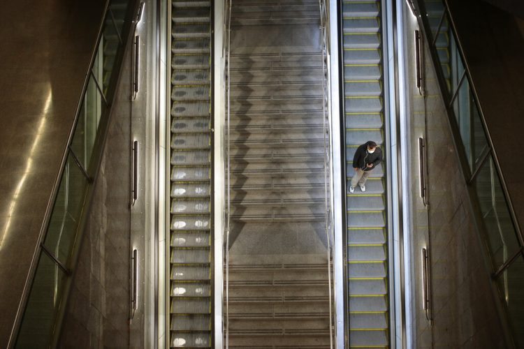 Un hombre sobre la escalera eléctrica de una estación de tren vacía en Barcelona. Foto: Joan Mateu/AP.