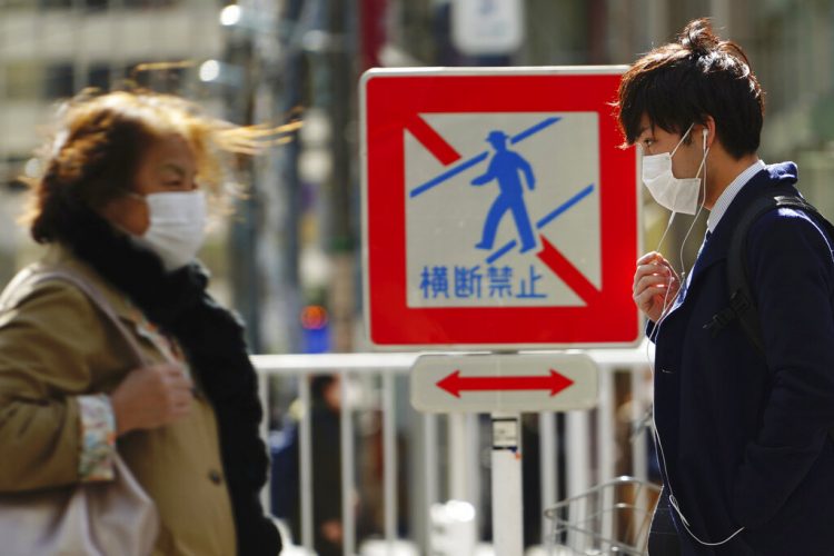 Peatones con mascarillas en una calle el jueves 5 de marzo de 2020 en Tokio, Japón. Foto: Eugene Hoshiko / AP.