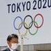 Un hombre con una mascarilla pasa junto a un cartel que anuncia los Juegos Olímpicos de Tokio del 2020, ya pospuestos para el próximo año. Foto: Koji Sasahara / AP / Archivo.