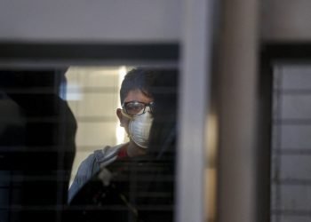 Un pasajero con una mascarilla en un elevador antes de abordar un vuelo en el Aeropuerto Internacional Arturo Benítez en Santiago de Chile, 3 de marzo de 2020. Foto: Esteban Félix/AP.