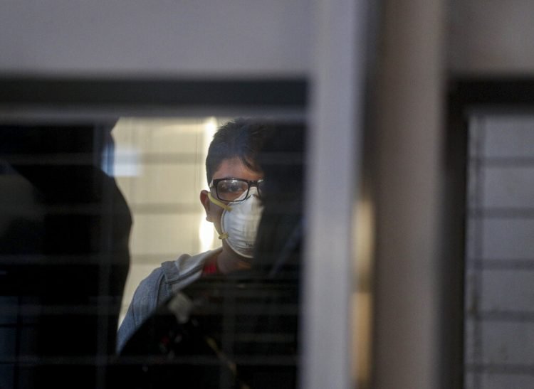 Un pasajero con una mascarilla en un elevador antes de abordar un vuelo en el Aeropuerto Internacional Arturo Benítez en Santiago de Chile, 3 de marzo de 2020. Foto: Esteban Félix/AP.