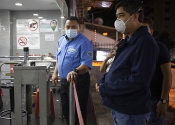 Un cliente espera ingresar a un supermercado en Caracas. Foto: Ariana Cubillos/AP.