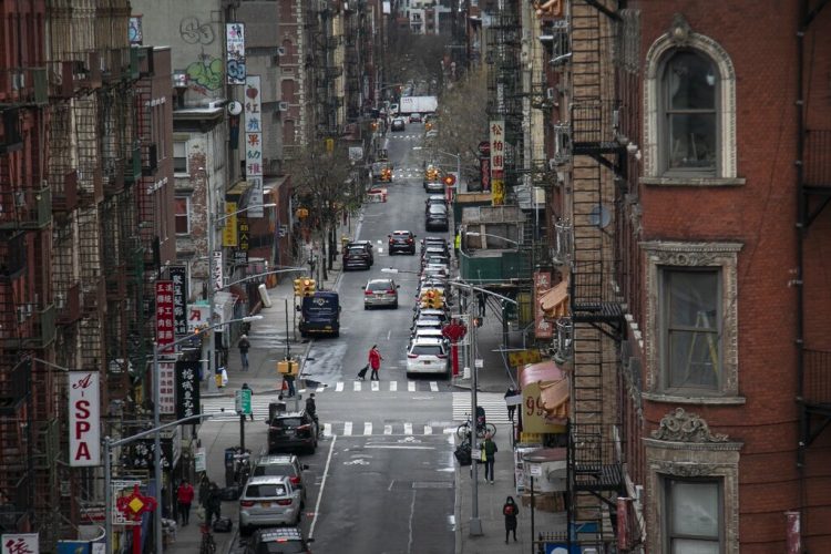 Una mujer cruza una calle con su carro de supermercado en las calles de Chinatown, el jueves 19 de marzo de 2020 en Nueva York. Foto: Wong Maye-E / AP.