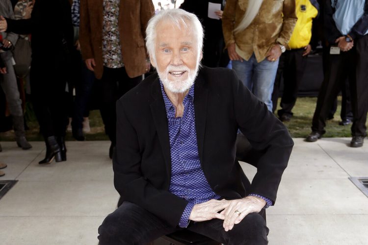 En esta imagen de archivo, tomada el 24 de octubre de 2017, Kenny Rogers posa con su estrella en el Paseo de la Fama de la Música, en Nashville, Tennessee. El cantante murió el viernes 20 de marzo de 2020. Tenía 81 años.  (AP Foto/Mark Humphrey, archivo)