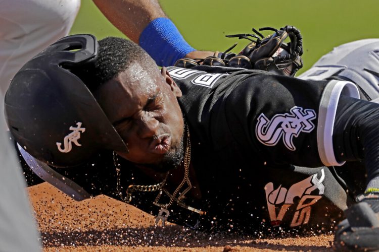 El cubano Luis Robert, de los Medias Blancas de Chicago, es puesto out por Todd Frazier, antesalista de los Rangers de Texas, en un encuentro de pretemporada realizado el sábado 29 de febrero de 2020, en Surprise, Arizona. Foto: AP /Charlie Riedel