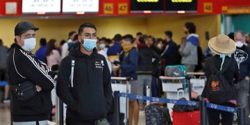 Varias personas esperan la salida de sus vuelos antes del cierre parcial de las fronteras cubanas para evitar la propagación de la COVID-19, en el Aeropuerto Internacional "José Martí" de La Habana, el 23 de marzo de 2020. Foto: Yander Zamora / EFE.