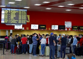 Un grupo de personas esperan la salida de sus vuelos antes del cierre parcial de las fronteras cubanas para evitar la propagación de la COVID-19, en el Aeropuerto Internacional "José Martí" de La Habana, el 23 de marzo de 2020. Foto: Yander Zamora / EFE.