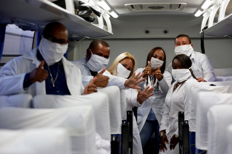 Miembros de la Brigada médica que llegara hoy a Sudáfrica posan para una foto de despedida en el interior del ómnibus que los llevaba al aeropuerto internacional José Martí, este sábado, en La Habana. El grupo viaja en un vuelo especial de South African Airways, que debe arribar a Johannesburgo cerca de la medianoche de este domingo. Sudáfrica es el cuarto país africano al que acuden profesionales cubanos en medio de la pandemia. Foto: EFE/ Ernesto Mastrascusa.