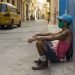 Un hombre sentado en una acera de La Habana, con un nasobuco como medida de protección contra la pandemia de coronavirus. Foto: Otmaro Rodríguez.