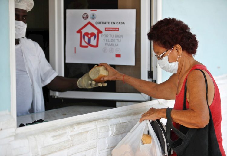 Una mujer con tapabocas compra pan en La Habana. Foto: EFE/Yander Zamora.