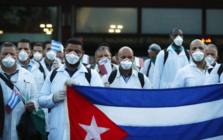 Personal médico cubano posa a su llegada al aeropuerto Malpensa de Milán, Italia, el domingo 22 de marzo de 2020, para ayudar en la atención a los enfermos de covid-19. Foto: AP / Antonio Calanni.