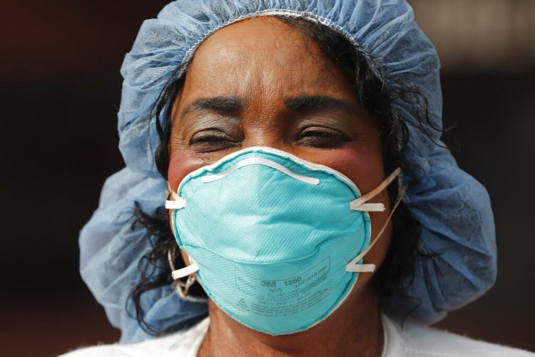 Kate Ikenyi, enfermera del hospital del condado de Cook, se une a una protesta el lunes 6 de abril de 2020, en el vecindario Hyde Park de Chicago. Foto: Charles Rex Arbogast/AP.