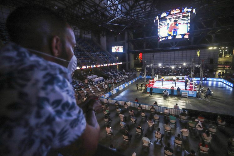 Un hombre con mascarilla ve un combate en una velada de boxeo organizada por el bicampeón del mundo de boxeo Rosendo "Búfalo" Álvarez en Managua, Nicaragua, el sábado 25 de abril de 2020.  Foto: AP/Alfredo Zúñiga.