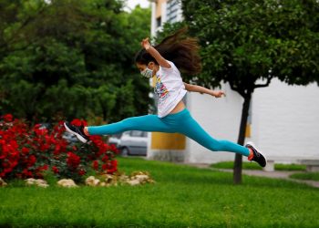Una niña con mascarilla salta en una calle en Córdoba, ESpaña, este domingo. Foto: Salas/EFE.
