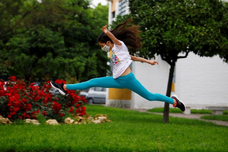 Una niña con mascarilla salta en una calle en Córdoba, ESpaña, este domingo. Foto: Salas/EFE.