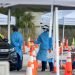 Los miembros de la Guardia Nacional usan equipo de protección mientras conducen hisopos nasales para pruebas de coronavirus en una ubicación de prueba en el estacionamiento del estadio Super Bowl de Hard Rock Cafe Miami, en Miami. Foto: Cristóbal Herrera/EFE/EPA.