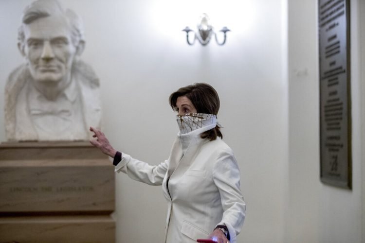 Un busto del expresidente estadounidense Abraham Lincoln detrás de la presidenta de la Cámara de Representantes, Nancy Pelosi, al llegar a la sede del Congreso el 23 de abril de 2020 en Washington. Foto: Andrew Harnik/AP.