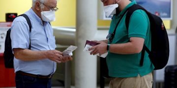 Dos turistas españoles revisan sus boletos de vuelo este martes en el aeropuerto Internacional José Martí de la Habana, Cuba. Foto: EFE/ Ernesto Mastrascusa.