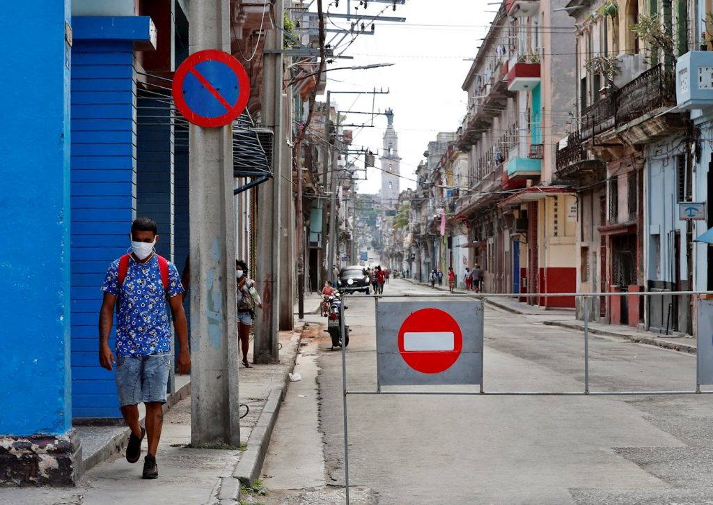 Un hombre con tapabocas pasa por una calle con acceso restringido por la Covid-19 en La Habana. Foto: Ernesto Mastrascusa / EFE.