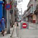 Un hombre con tapabocas pasa por una calle con acceso restringido por la Covid-19 en La Habana. Foto: Ernesto Mastrascusa / EFE.