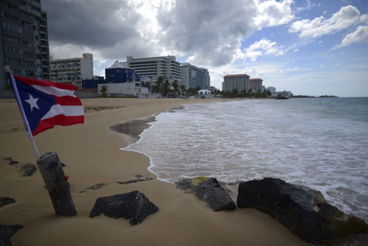 Una bandera puertorriqueña ondea en una playa vacía el 21 de mayo de 2020 en San Juan. Foto: Carlos Giusti/AP.