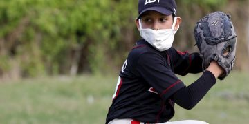 Jorge Alejandro Rodríguez usa una mascarilla en un entrenamiento de béisbol durante la cuarentena por el coronavirus en un terreno cerca de su casa en la tarde del 8 de mayo de 2020 en La Habana (Cuba). Foto: EFE/Ernesto Mastrascusa.