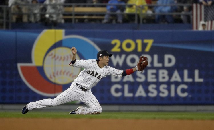 En esta imagen del 21 de marzo de 2017, el japonés Hayato Sakamoto realiza una atrapada al batazo del estadounidense Buster Posey en la cuarta entrada del juego semifinal del Clásico Mundial de Béisbol en Los Ángeles. (AP Foto/Chris Carlson, Archivo)