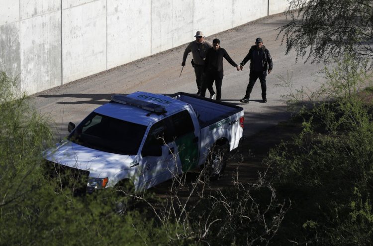 Foto de archivo donde un agente de la Aduana y la Patrulla Fronteriza de Estados Unidos camina con presuntos inmigrantes atrapados entrando ilegalmente al país a lo largo del Río Grande, en Hidalgo, Texas. Foto: AP/Eric Gay.