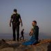 Un agente de policía habla con un hombre en una playa reabierta para actividades deportivas en Barcelona. Foto: Emilio Morenatti/AP