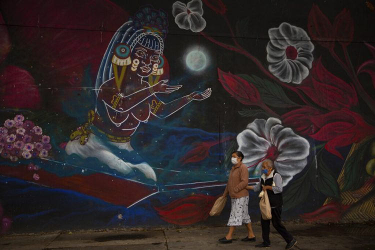 Mujeres con nasobucos caminan fuera del mercado cerrado de flores Jamaica en la Ciudad de México, jueves 7 de mayo de 2020. Foto: Fernando Llano/AP.