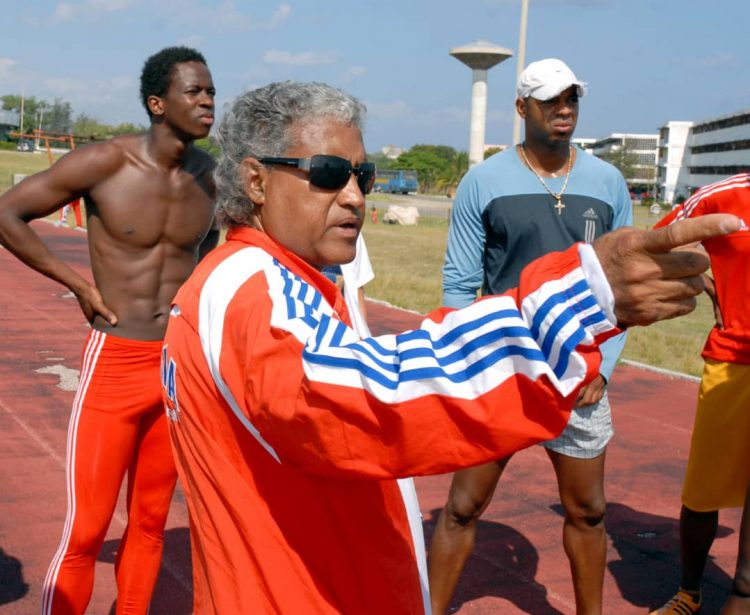 Santiago Antúnez junto a Dayron Robles y Anier García, los dos corredores que llevó al título olímpico. Foto: Ricardo López Hevia.