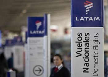 Una empleada de LATAM Airlines junto a los mostradores de facturación en el aeropuerto de Santiago de Chile. Foto: Esteban Félix/AP