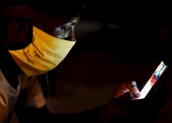 Un joven con tapabocas observa su teléfono en Cuba. Foto: Yander Zamora / EFE / Archivo.