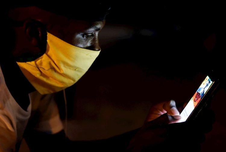 Un joven con tapabocas observa su teléfono en Cuba. Foto: Yander Zamora / EFE / Archivo.