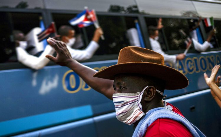 Un hombre saluda a un grupo de doctores, parte de la primera brigada médica cubana del Contigente Henry Reeve, el lunes 8 de junio de 2020 después de que llegaron a La Habana, Cuba. Los médicos habían viajado a Italia para ayudar con la emergencia por el COVID-19. Foto: Ramón Espinosa/AP