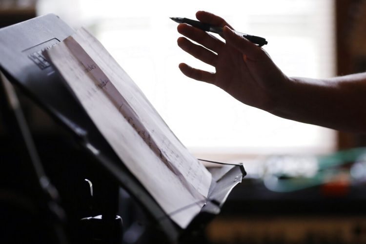 En esta foto del 22 de mayo de 2020, la enfermera Megan Palmer escribe una canción durante una sesión de composición con su colega Anna Henderson en la casa de Henderson, en Ashland City, Tennessee. Foto: Mark Humphrey/ AP