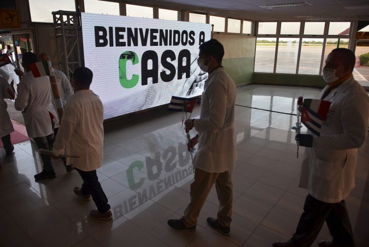 Un letrero de bienvenida recibe a los médicos cubanos que llegan desde Europa este lunes, a La Habana (Cuba). La primera brigada médica cubana del contingente "Henry Reeve" llegó este lunes al Aeropuerto Internacional José Martí luego de dos meses de misión en Italia. Foto: EFE/Yamil Lage.