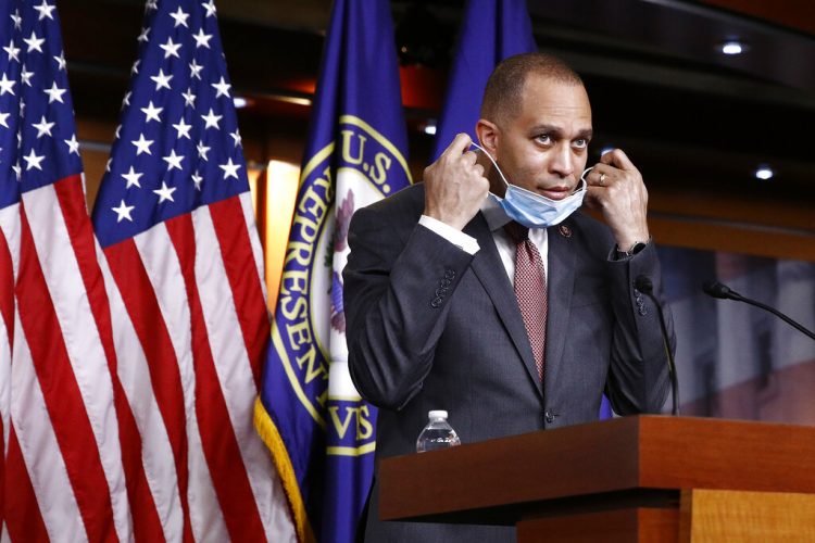 El jefe de la bancada demócrata, el representante Hakeem Jeffries, se retira una mascarilla antes de responder la pregunta de un reportero en el Capitolio. Foto: Patrick Semansky/AP.