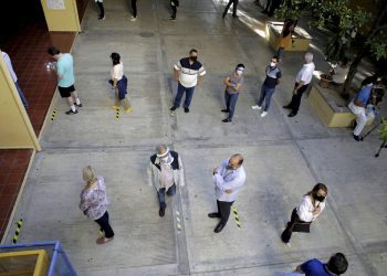 Votantes con mascarillas para protegerse de la propagación del nuevo coronavirus esperan en la fila para sufragar durante las elecciones presidenciales, en Santo Domingo, República Dominicana, el domingo 5 de julio de 2020. (Foto AP/Tatiana Fernández)