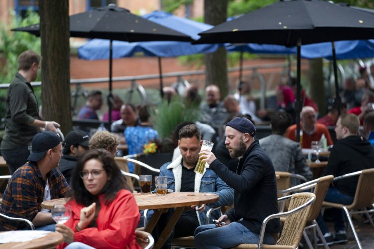 Personas sentadas en un bar en la calle Canal en la aldea gay de Manchester, Inglaterra, el sábado 4 de julio de 2020. (AP Foto/Jon Super)