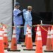 Trabajadores de la salud se ayudan mutuamente a colocarse equipo protector en un sitio de testeo del coronavirus en Miami Gardens, Florida, 5 de julio de 2020.  
Foto: Wilfredo Lee/Ap.