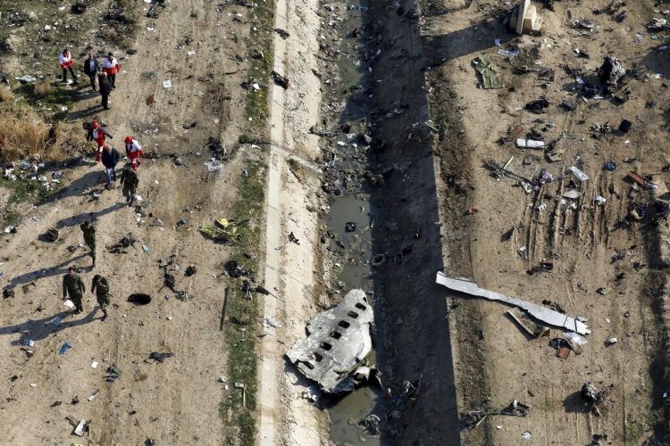 ARCHIVO - En esta imagen de archivo del 8 de enero de 2020, rescatistas trabajando en el lugar donde se estrelló un avión ucraniano en Shahedshahr, al suroeste de Teherán, Irán. Investigadores iraníes responsabilizaron a una batería de misiles mal colocada y a un error de comunicación entre soldados y sus comandantes por el siniestro de un avión ucraniano de pasajeros derribado en enero por la Guardia Revolucionaria. Murieron 176 personas. (AP Foto/Ebrahim Noroozi, Archivo)