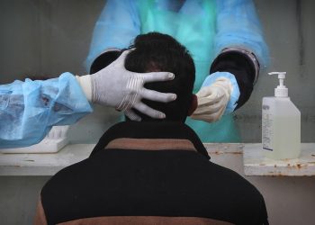 Personal médico extrae una muestra nasal a una persona para una prueba de detección del coronavirus en un hospital gubernamental en Hyderabad, India, el 23 de julio de 2020. (AP Foto/Mahesh Kumar A.)